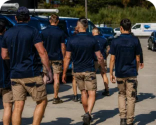 Plumbers walking to their service vans on a Hinchinbrook job
